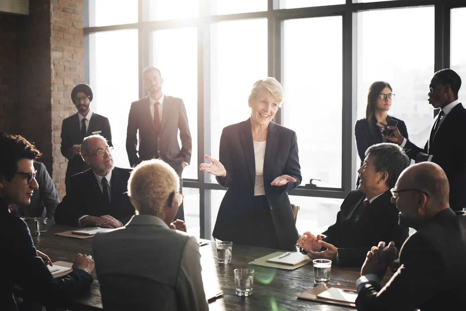 A group of people sitting around a table in a meeting.