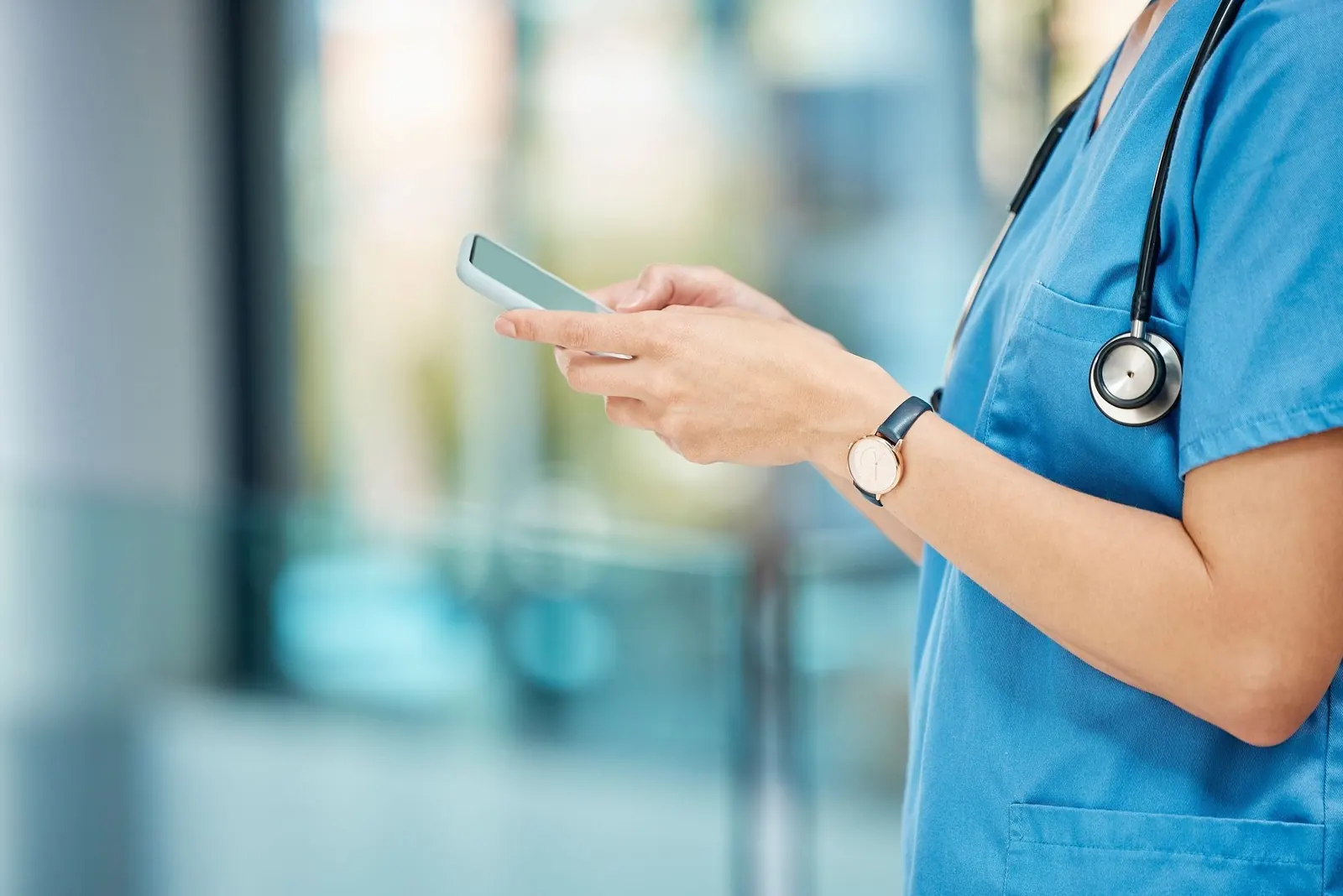 A nurse is using a cell phone in a care setting.