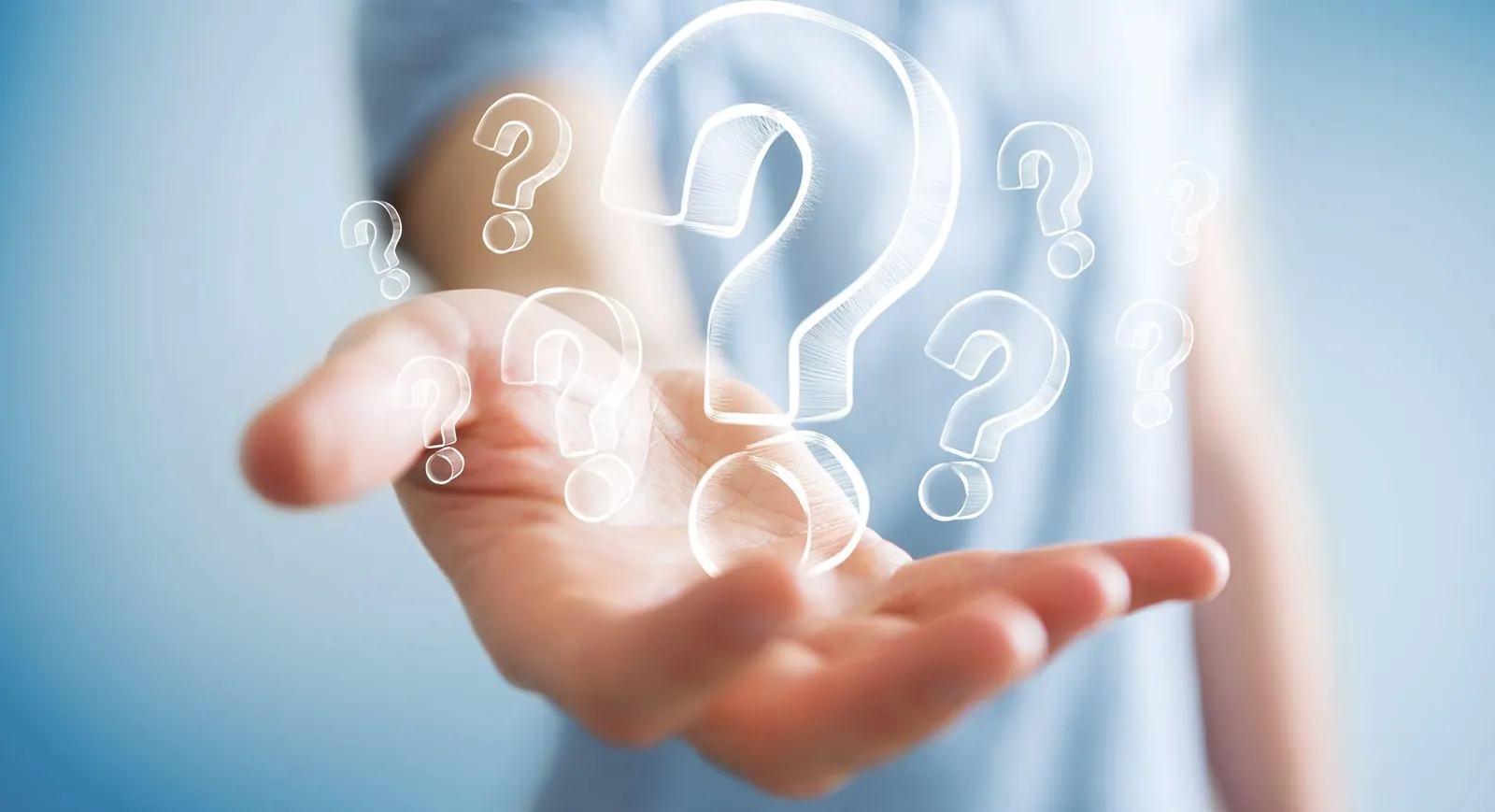 A person holding a hand with question marks.